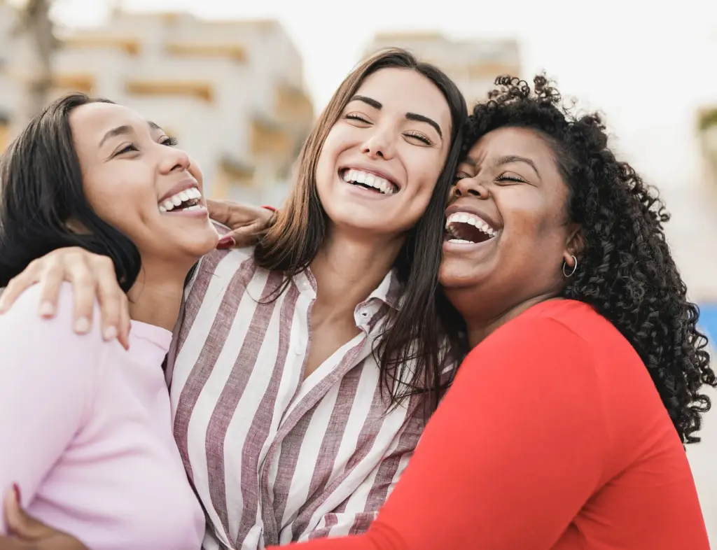 Friends laughing together with bright healthy smiles